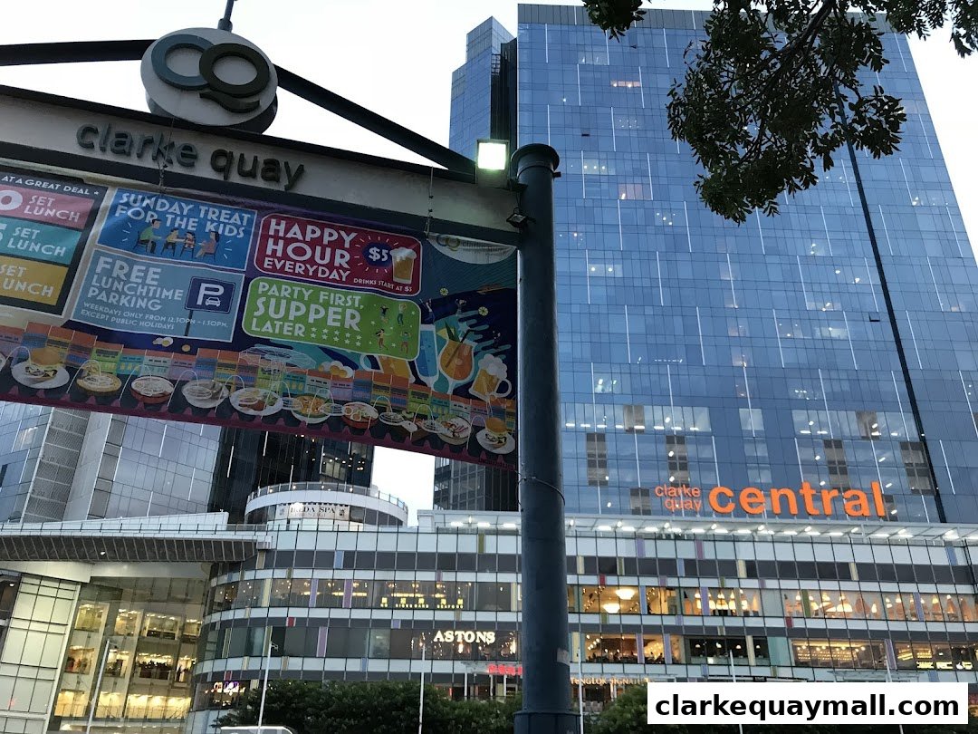 A street view of Clarke Quay Central with promotional banners and a modern glass building.