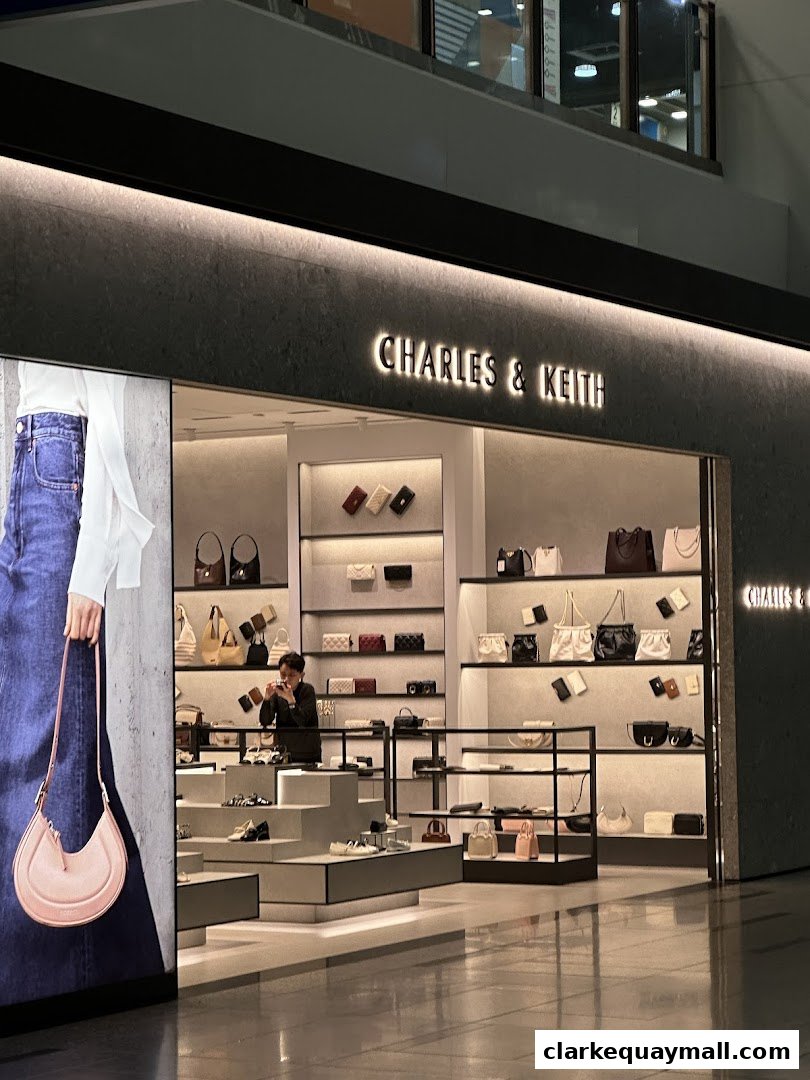 The Charles & Keith shop front displays a variety of handbags and shoes on illuminated shelves.