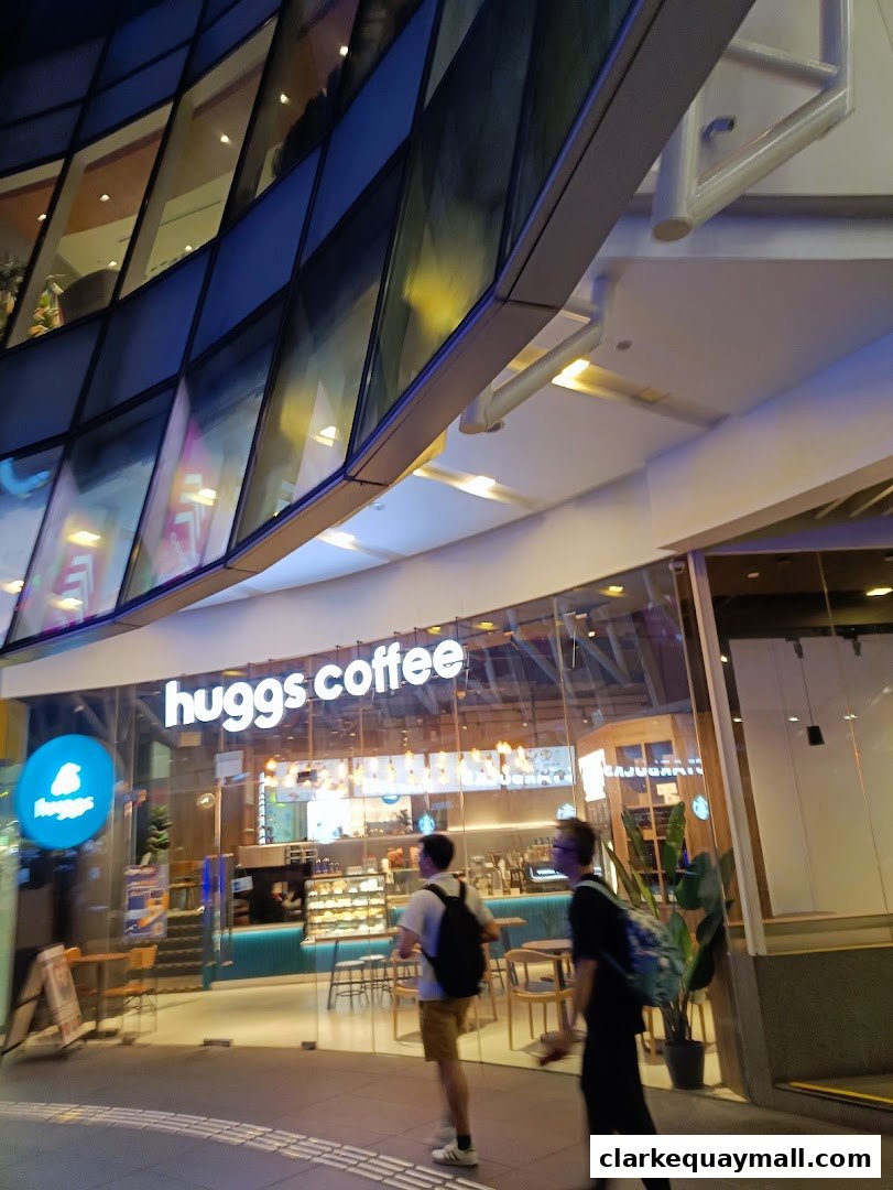 The exterior of a Huggs Coffee shop with people walking by.