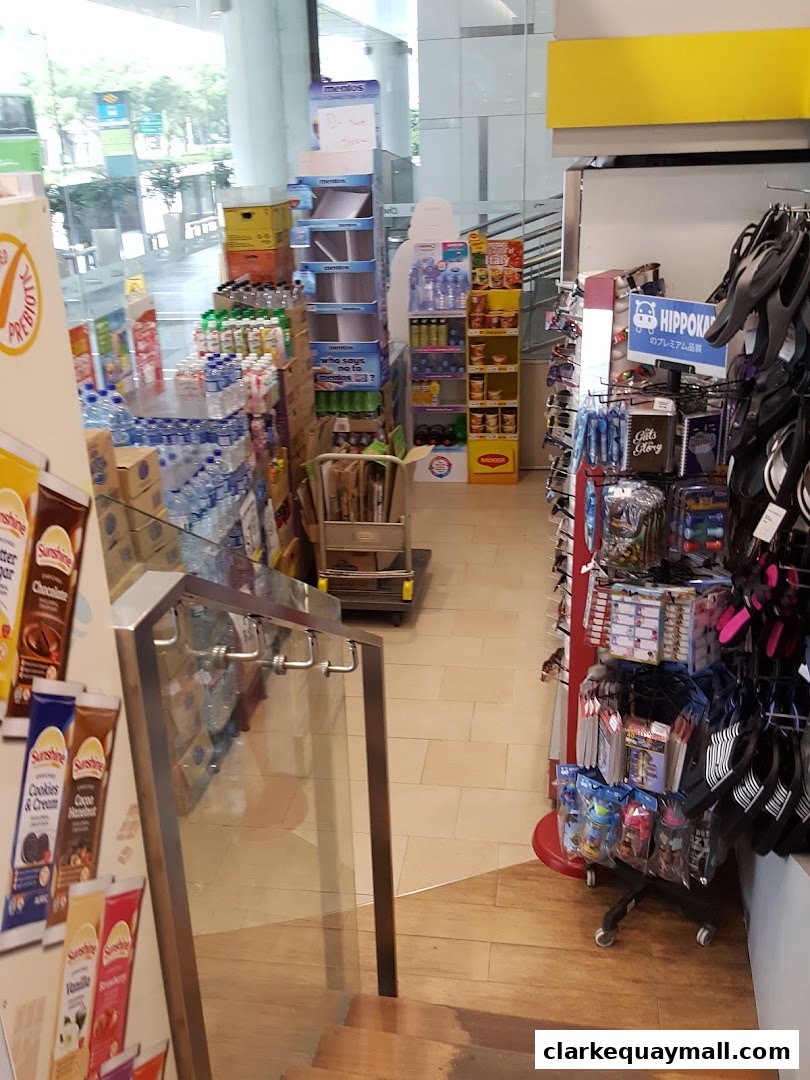 Interior view of a shop with shelves stocked with drinks, snacks, and various merchandise.