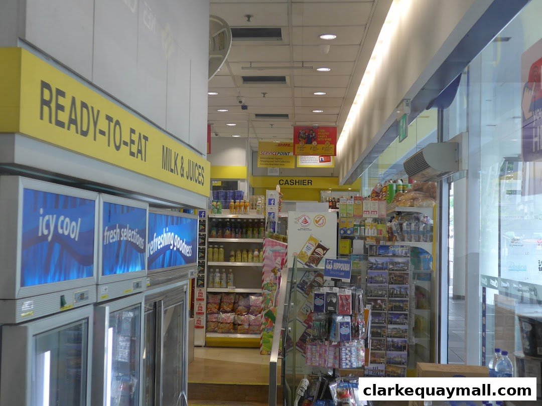 Interior view of a convenience store with refrigerators, shelves stocked with goods, and a cashier counter.