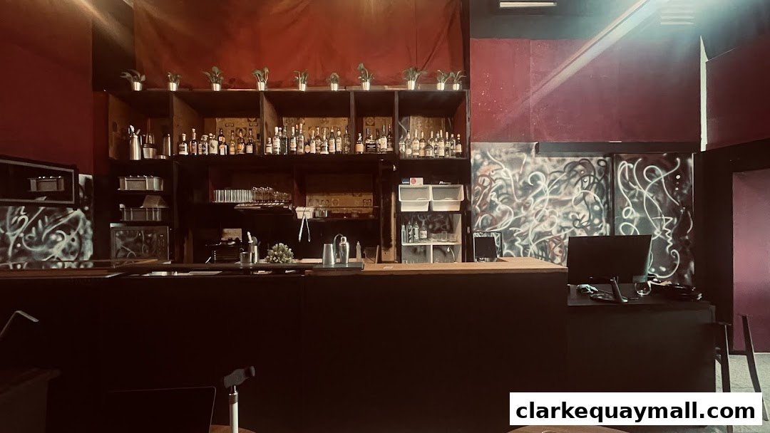Interior of a bar with shelves stocked with bottles and glassware, featuring graffiti art on the walls.