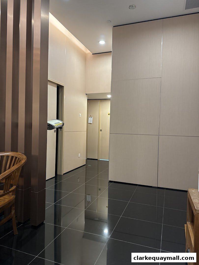 A clean and modern hallway with tiled floors and light-colored walls.
