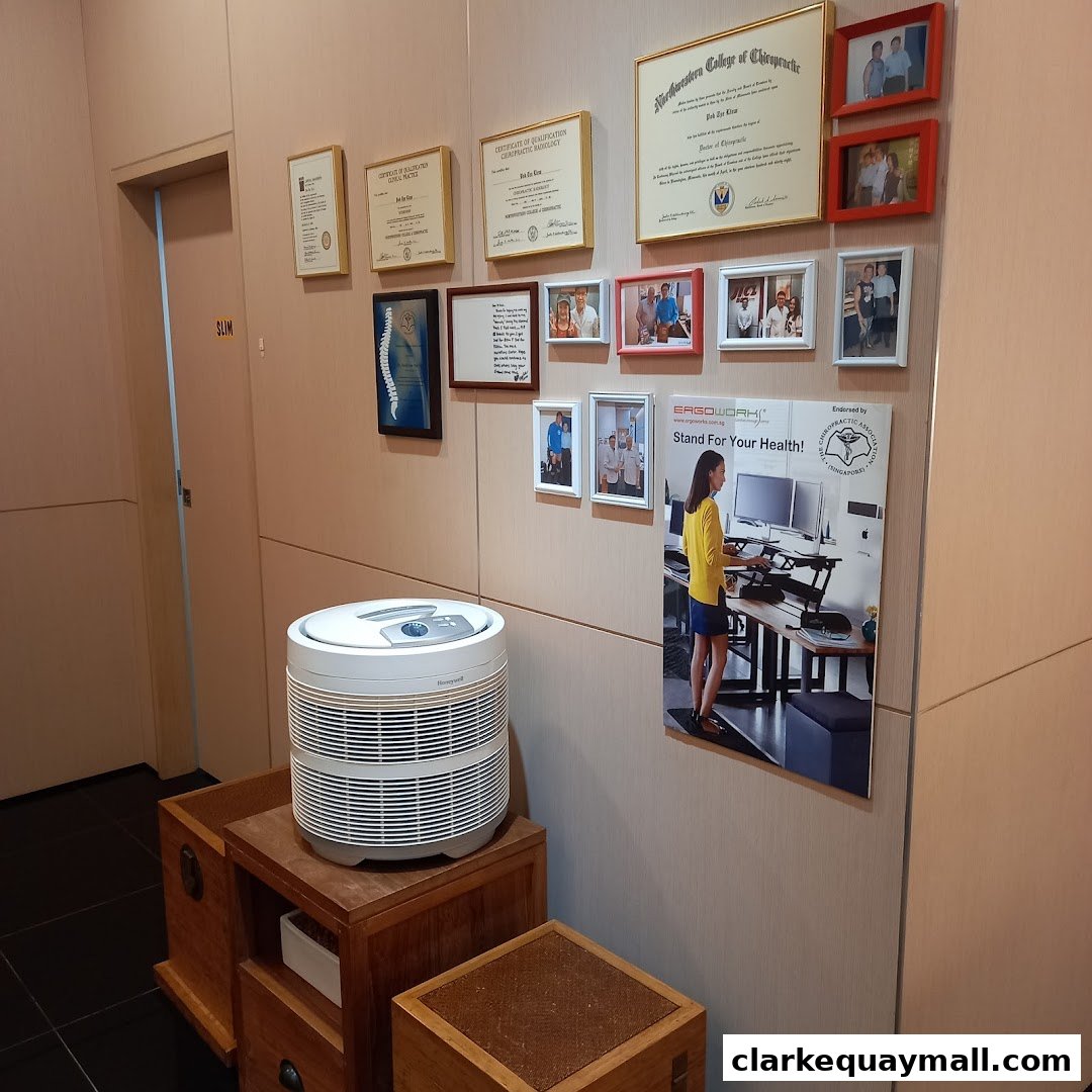 Wall with chiropractic certificates, photos, and a health poster.