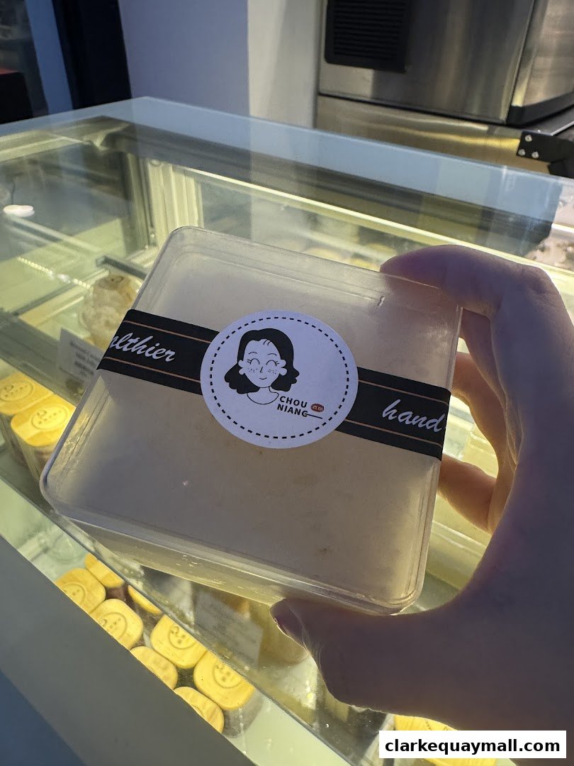 A hand holds a packaged dessert from Chou Niang Fermented Rice.