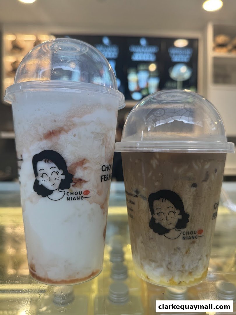Two takeaway drinks with clear lids, one white and red, the other brown and white.