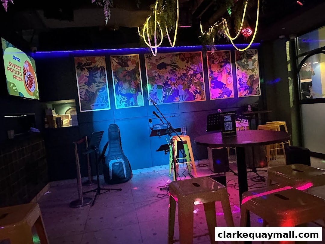 Interior of a bar with colorful artwork, musical instruments, and seating.