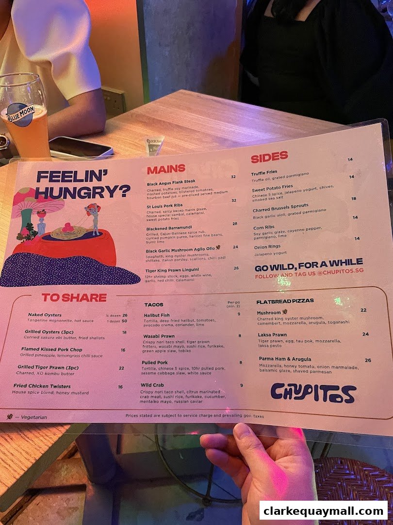 A person holds a menu from Chupitos, featuring food and drink options.