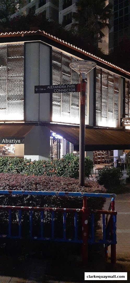 A shop front with an awning and signage, illuminated at night.