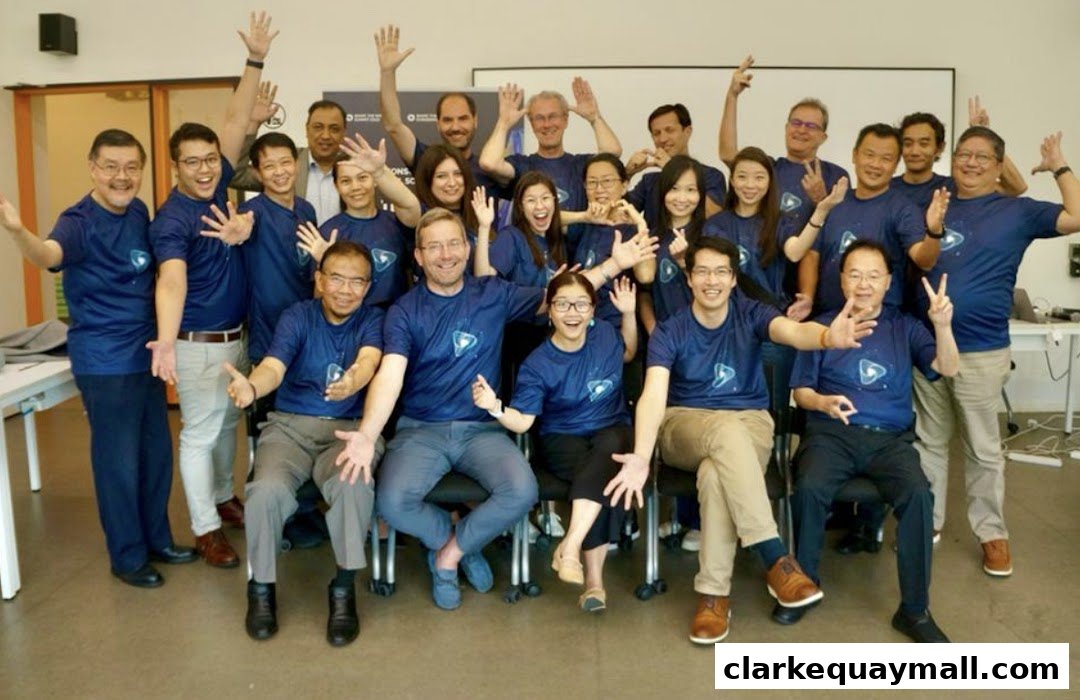 A diverse group of people in matching blue t-shirts with a logo, posing for a photo with raised hands.