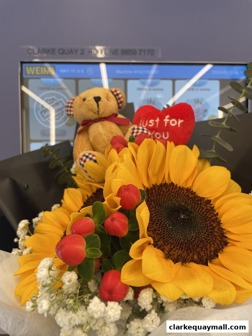 A bouquet of sunflowers, baby's breath, red berries, and a teddy bear with a 'just for you' heart.