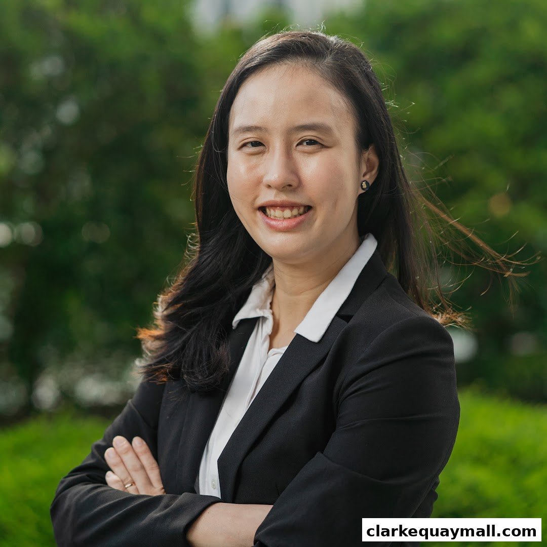 A professional portrait of a woman in a black blazer and white shirt, smiling.