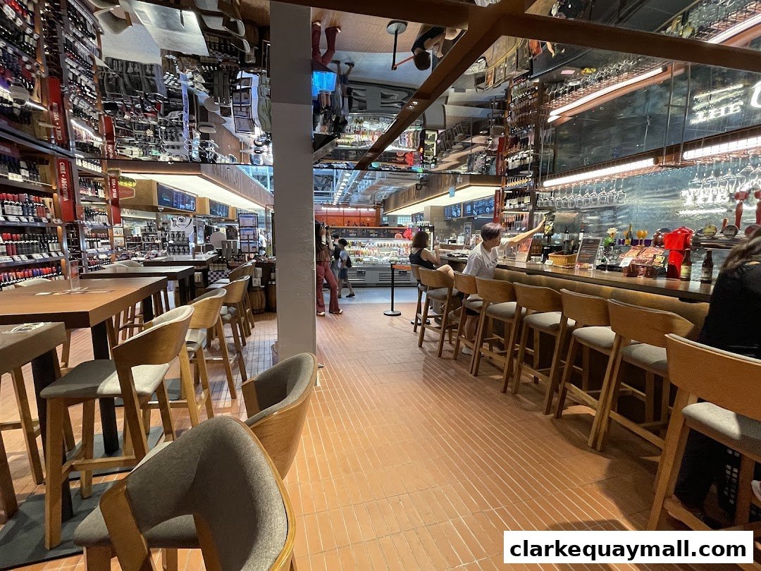 Interior view of Coyote Ugly Saloon Singapore with a bar, seating, and shelves stocked with bottles.