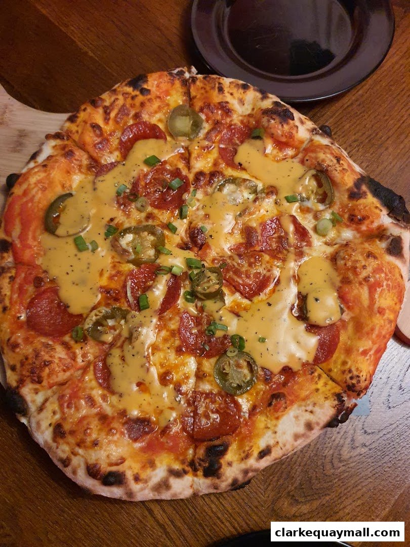 A close-up shot of a delicious pepperoni and jalapeño pizza with a cheese drizzle.