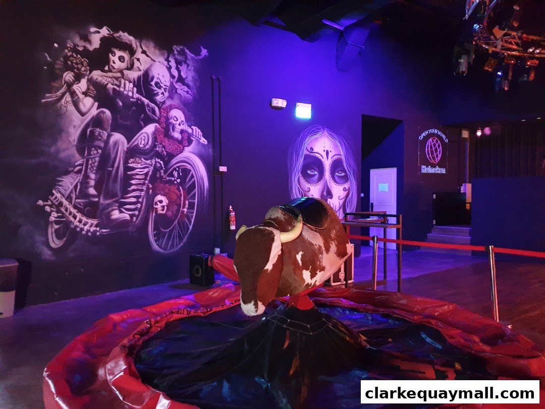 Interior of Coyote Ugly Saloon Singapore with a mechanical bull and themed wall art.