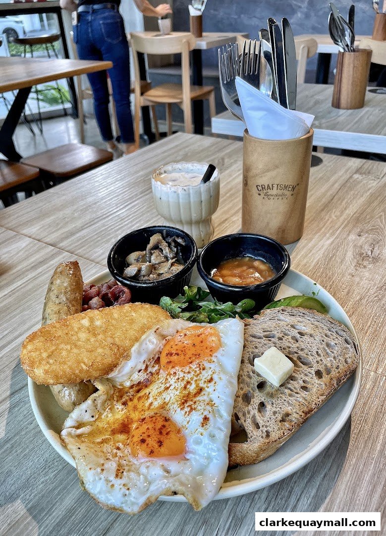A hearty breakfast platter with eggs, sausage, hash brown, toast, and sides.