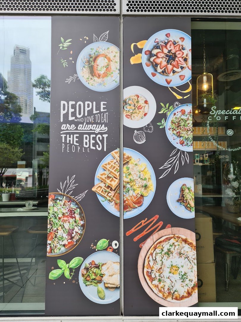 A shop front with a large graphic displaying various food items and a quote.