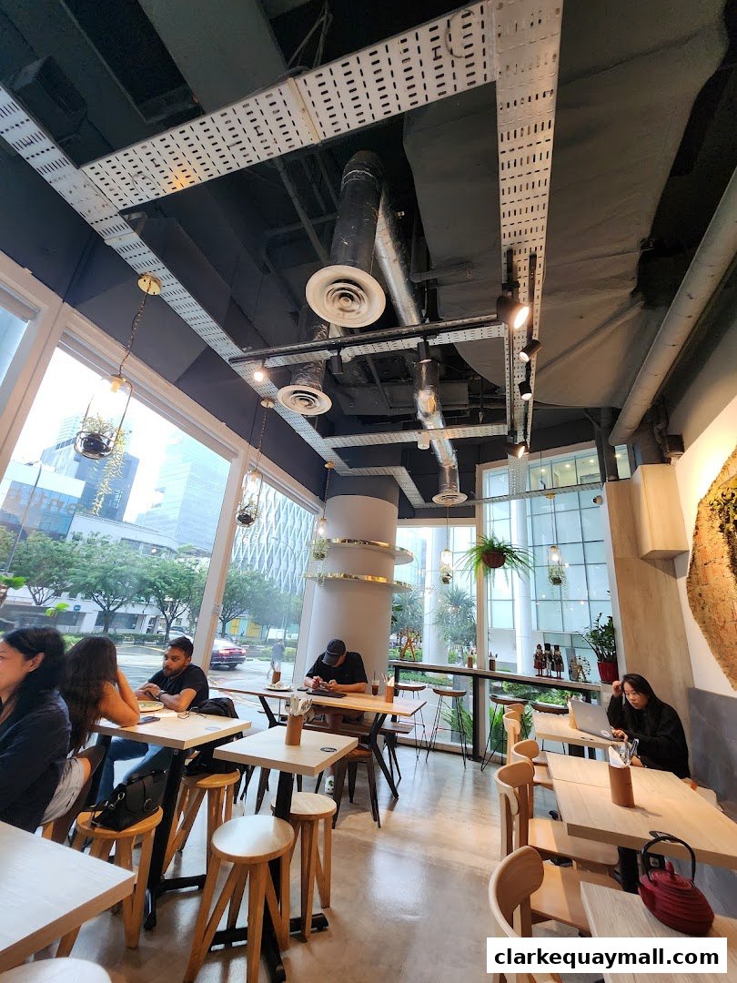 Interior view of a modern coffee shop with people seated at tables.