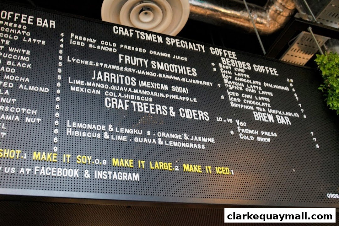 A black menu board with white lettering listing coffee, smoothies, Jarritos, craft beers, ciders, and brew bar options.