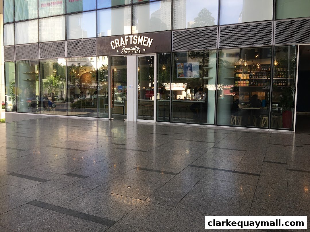 Exterior view of Craftsmen Specialty Coffee shop with large glass windows and interior seating.