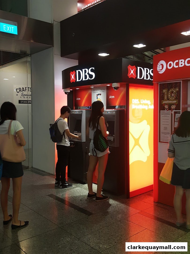 People using DBS and OCBC ATMs in a shopping mall.