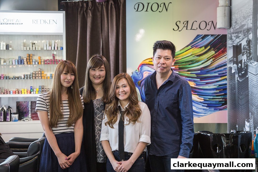 A team of four smiling people posing in front of shelves stocked with hair products.