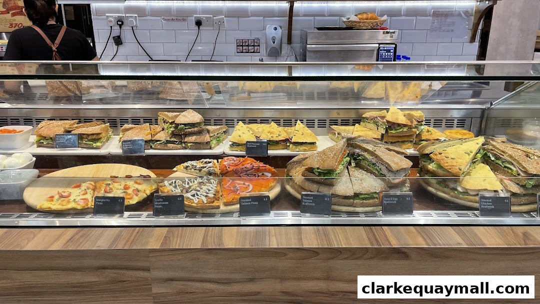 A display case filled with various sandwiches, pizzas, and baked goods.