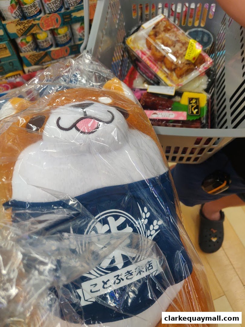 A shopping basket filled with Japanese snacks and a plush toy with Japanese writing.