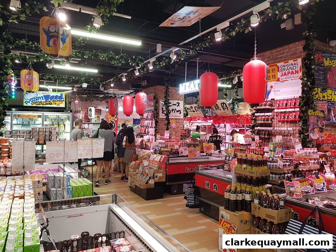 Interior view of a bustling Japanese supermarket with various food products and shoppers.