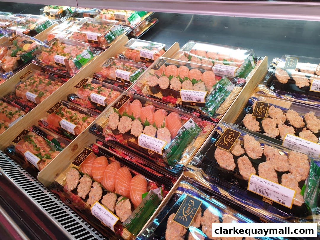 A display of pre-packaged sushi and salmon dishes in clear plastic containers.
