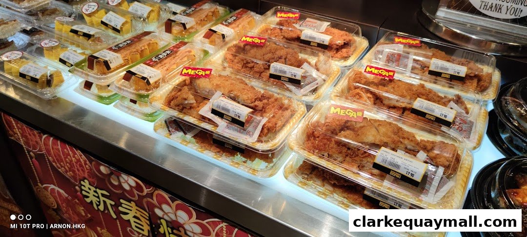 A display of pre-packaged fried chicken and other Japanese food items in clear plastic containers.