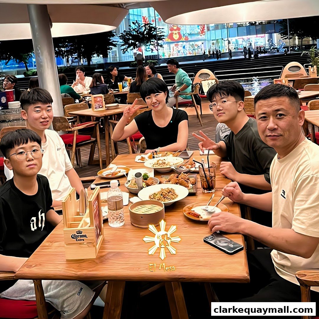 A family enjoys a meal at El Mesa Filipino Seafood Grill, with various dishes on the table.