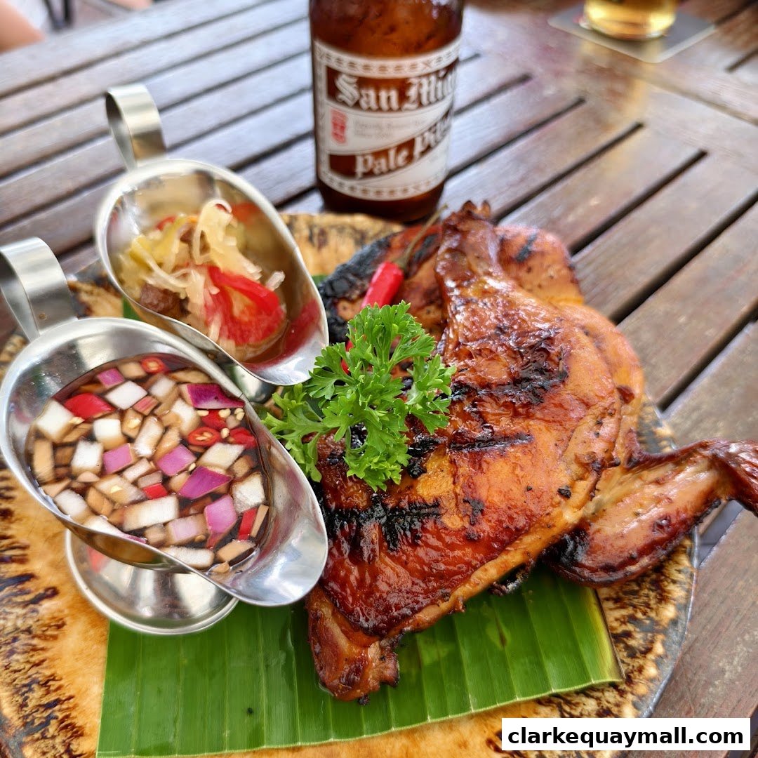 A grilled chicken dish with dipping sauces and a bottle of San Miguel beer.