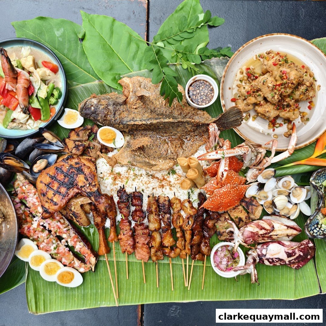 A bountiful spread of Filipino seafood and grilled meats served on banana leaves.