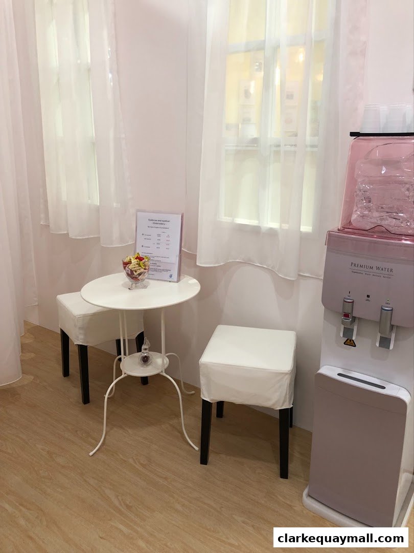 A waiting area with a small table, stools, and a water dispenser.