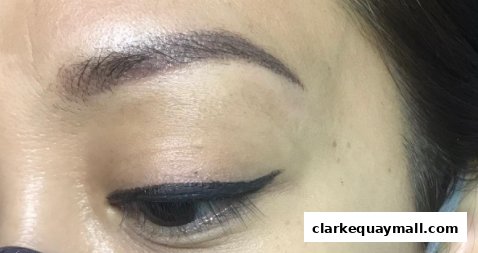 Close-up of a woman's eye with expertly applied eyeliner and defined eyebrows.