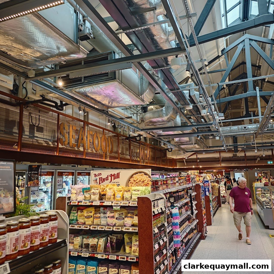 Interior view of a FairPrice Finest supermarket with aisles of groceries and a customer walking.