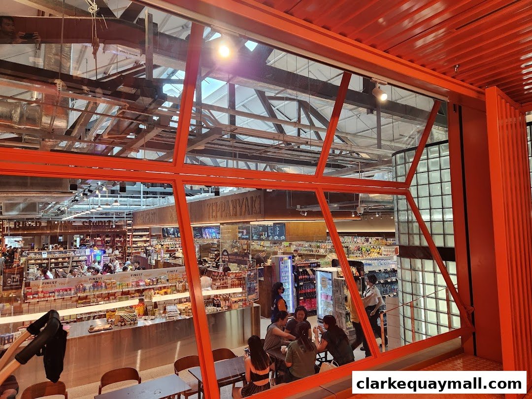 View of a busy FairPrice Finest supermarket interior with shoppers and diverse product displays.