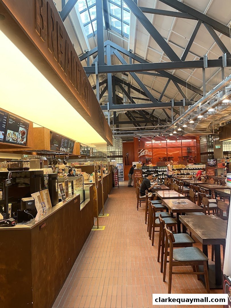 Interior view of a FairPrice Finest supermarket with a cafe area and seating.