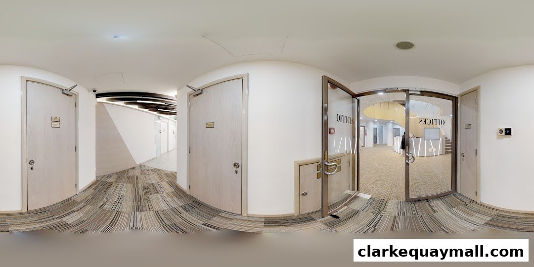 Interior view of a modern office hallway with doors and a reception area visible through glass.