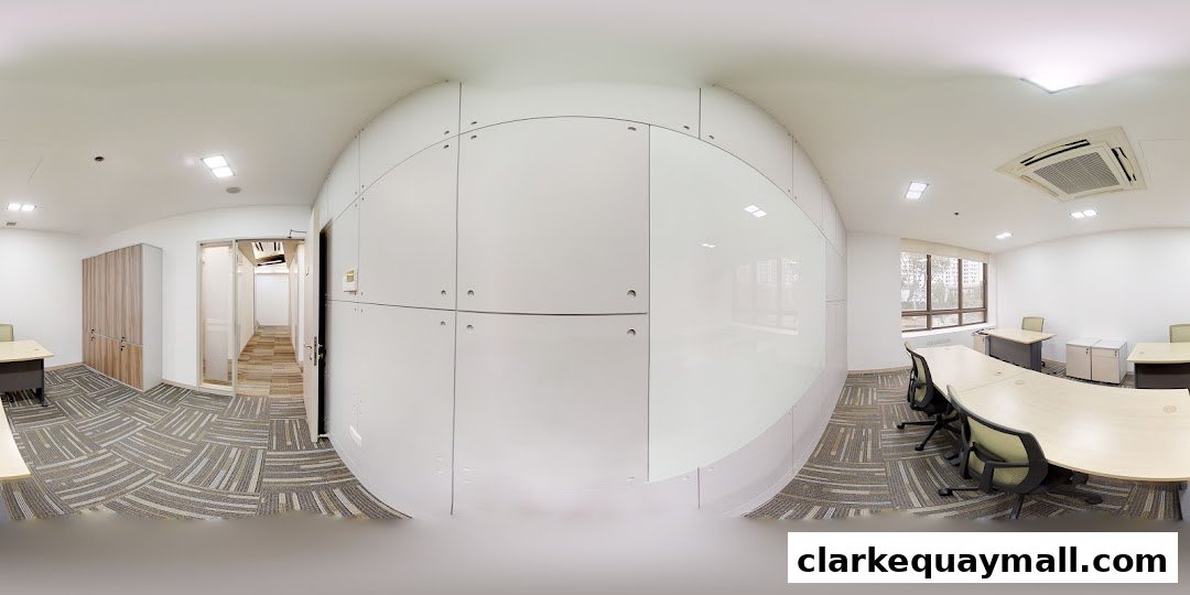 Modern office interior with desks, chairs, and a large curved wall.