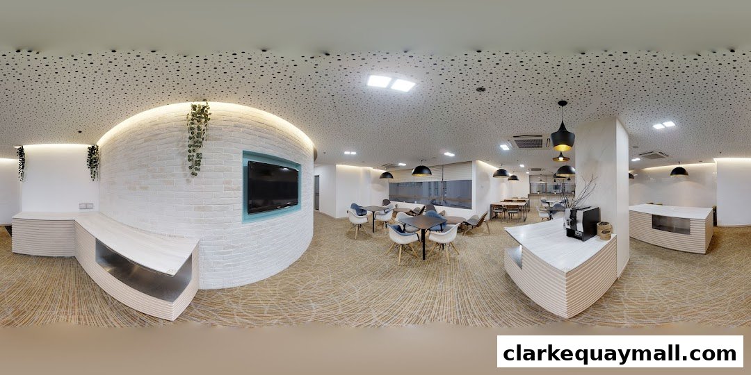 Interior view of a modern lounge area with seating, tables, and a reception desk.