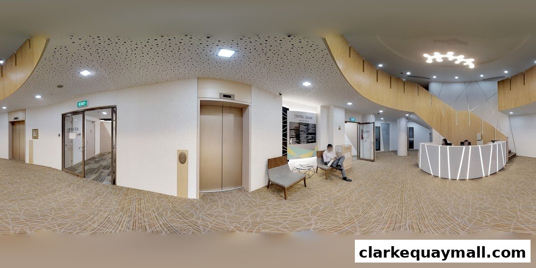 Interior view of a modern office building lobby with a reception desk and staircase.