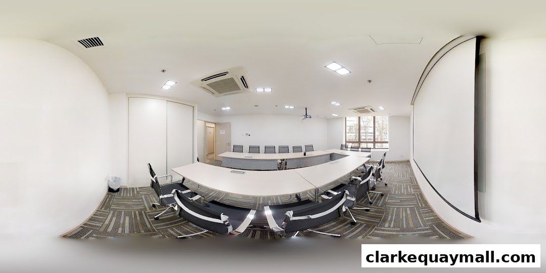 A modern conference room with a U-shaped table, chairs, projector, and screen.