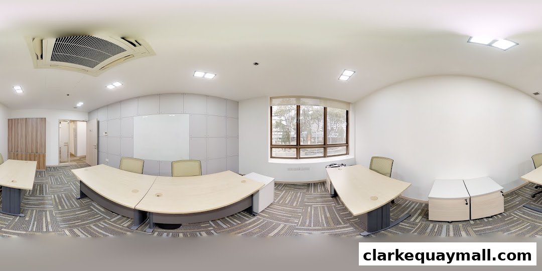 A modern office space with curved desks, chairs, and a whiteboard.