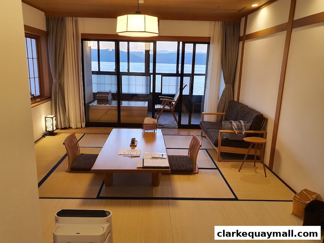 A Japanese-style room with tatami mats, a low table, and a view of the sea.