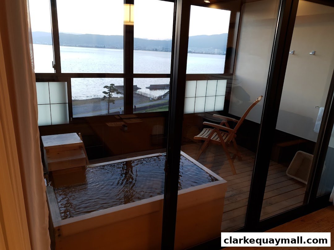A private indoor bath with a view of a lake and mountains.