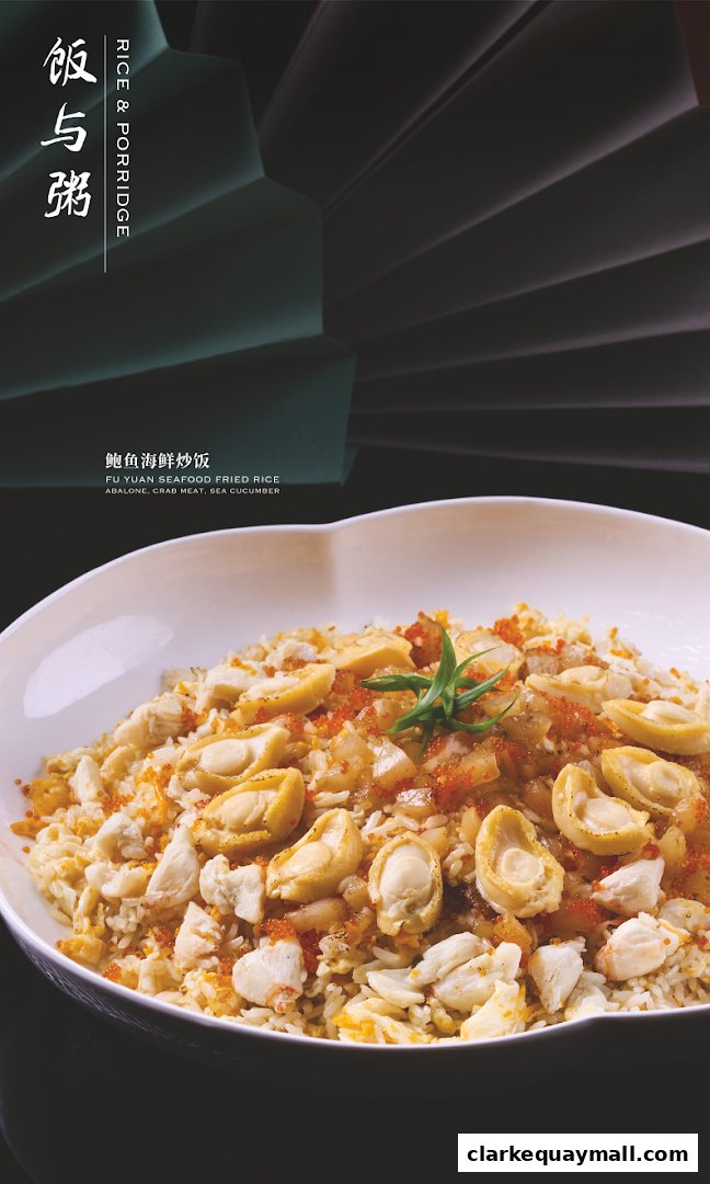 A close-up of a bowl of seafood fried rice with abalone, crab meat, and roe.