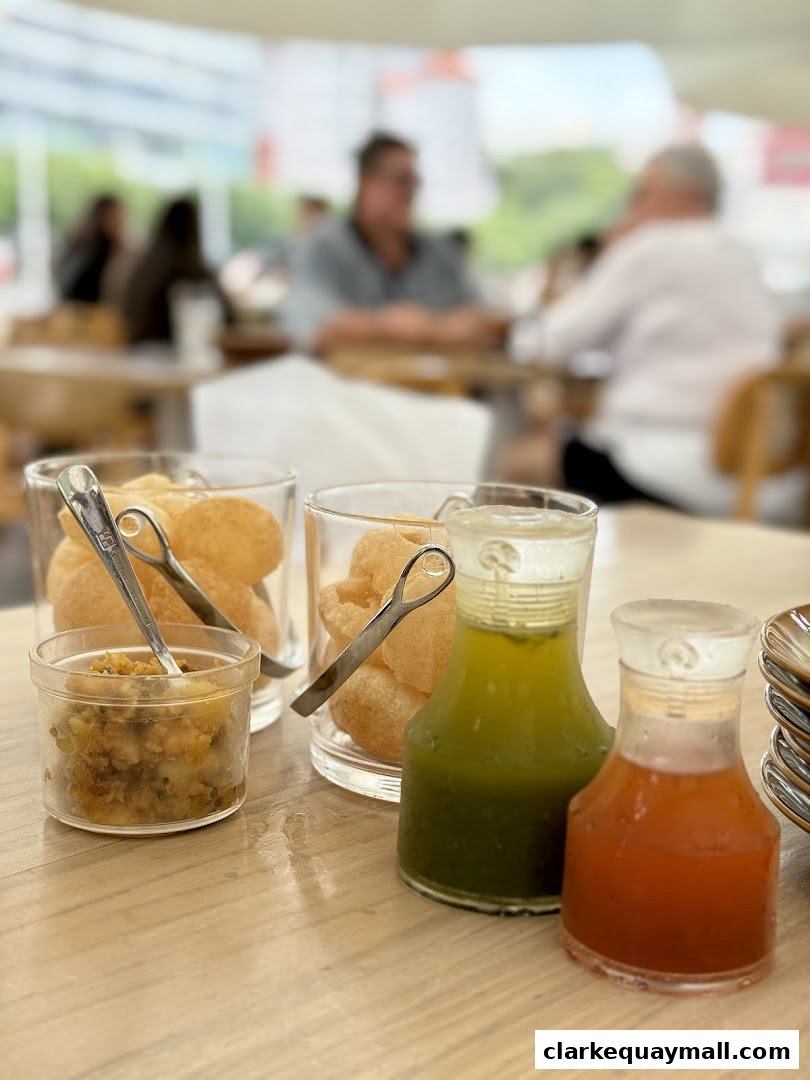 Close-up of Indian street food snacks and chutneys on a wooden table at Gabbar Bistro.