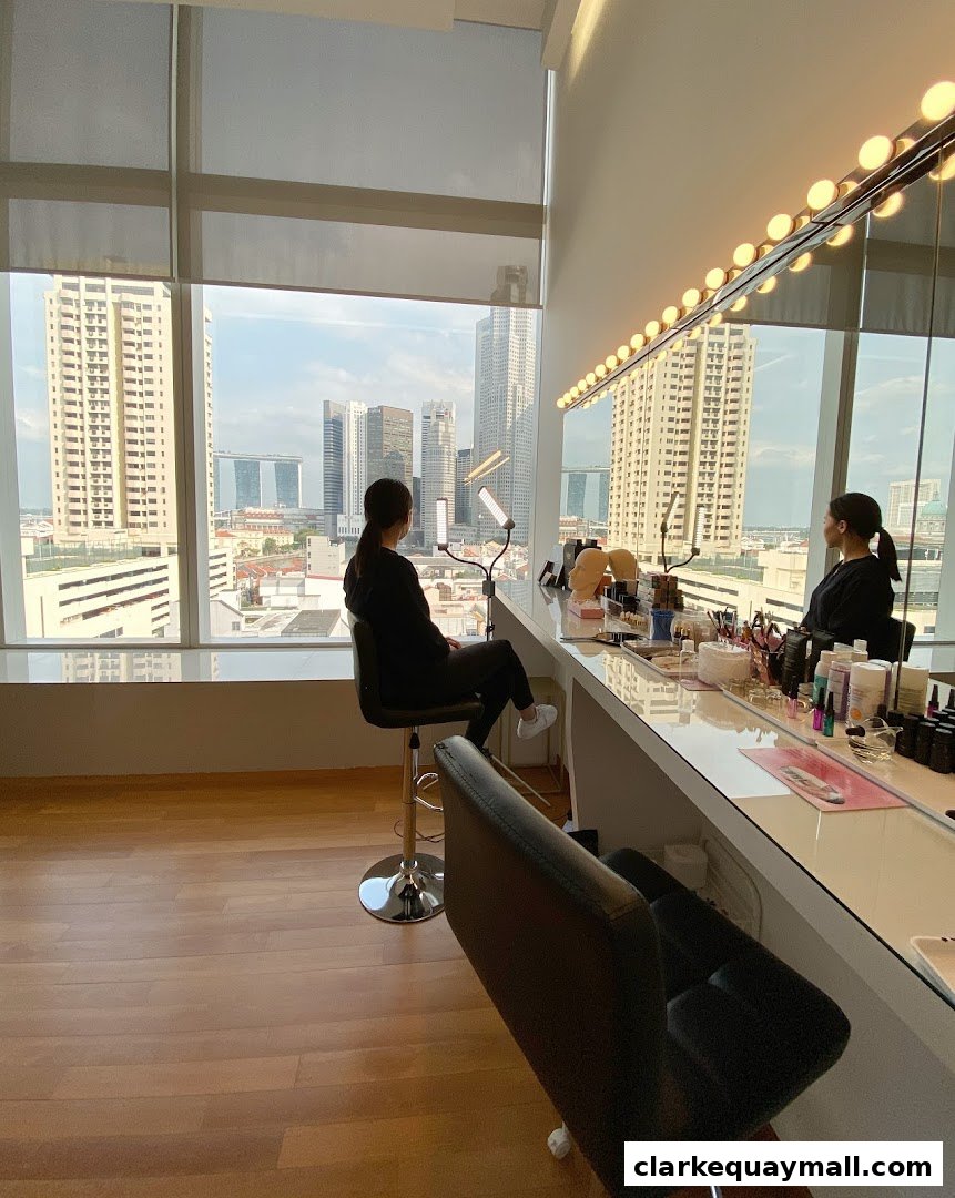 Two women are seated at a makeup counter with a city view, surrounded by beauty products.